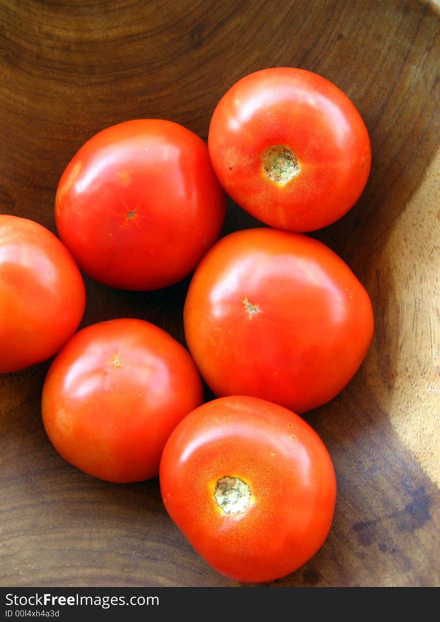 Some fresh tomatoes inside a wooden ball. Some fresh tomatoes inside a wooden ball