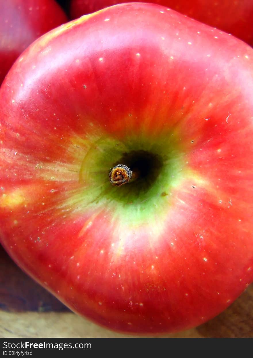 A macro of a red apple inside a bowl with other apples