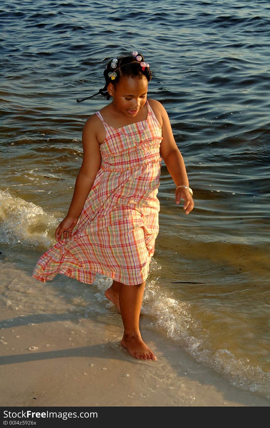 An african american girl walking along shoreline