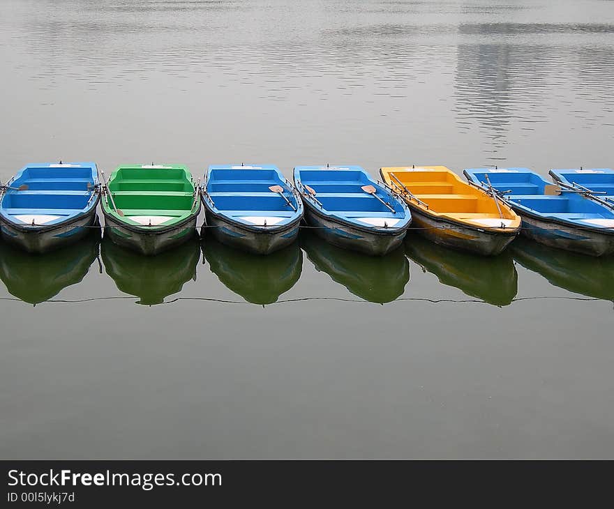 A row of colorful boats on the lake waiting for tourists. A row of colorful boats on the lake waiting for tourists