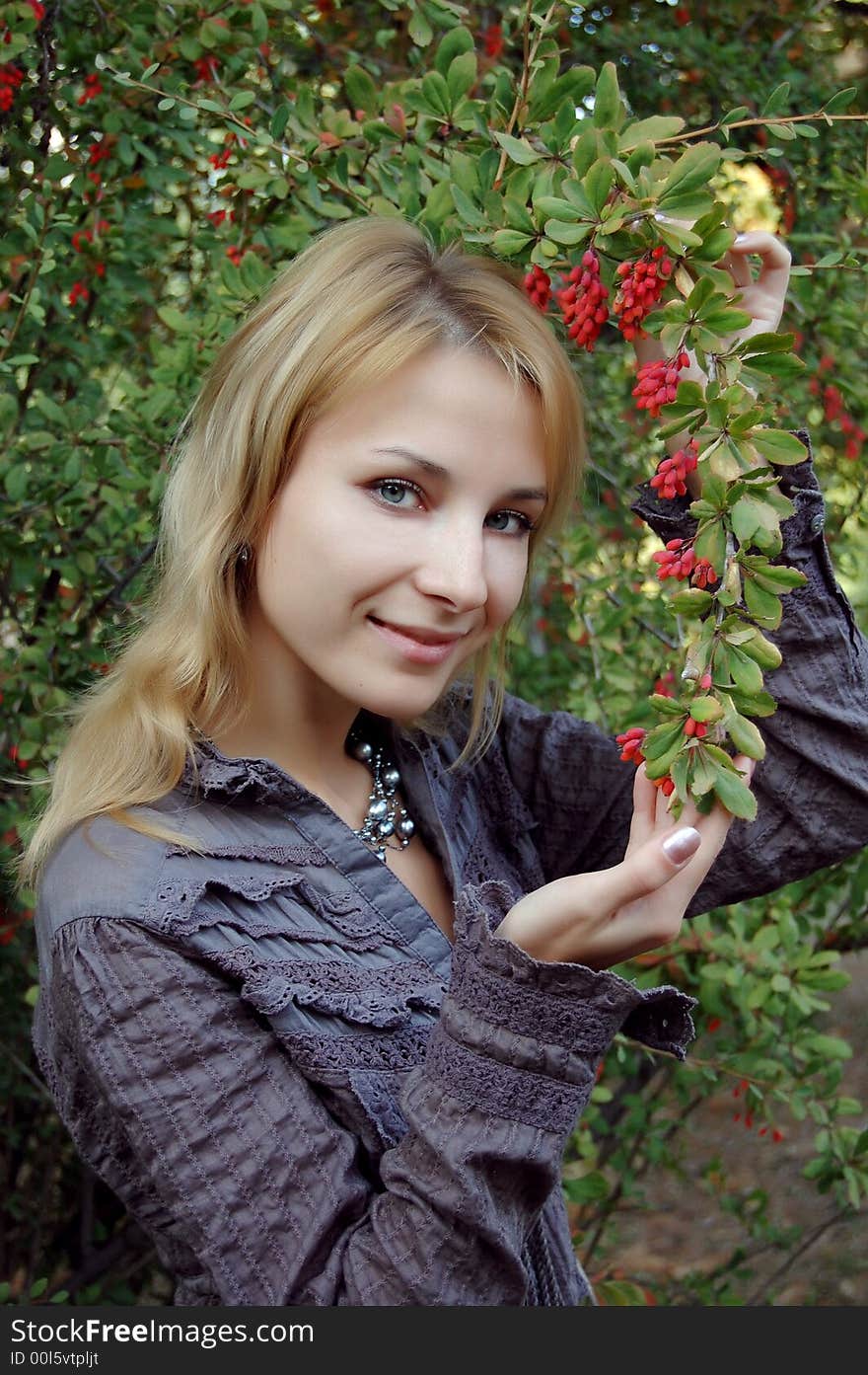 Pretty girl touching barberries and smiling. Pretty girl touching barberries and smiling