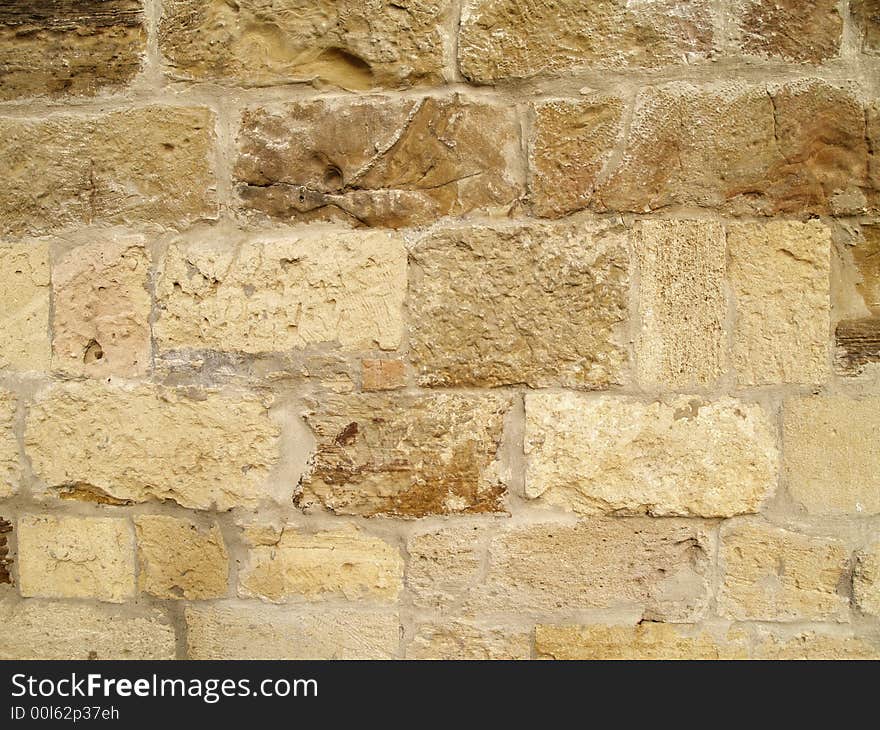 Horizontal view of a layered, sandstone exterior wall building facade. A close up of a brick wall which can be used as background. Horizontal view of a layered, sandstone exterior wall building facade. A close up of a brick wall which can be used as background