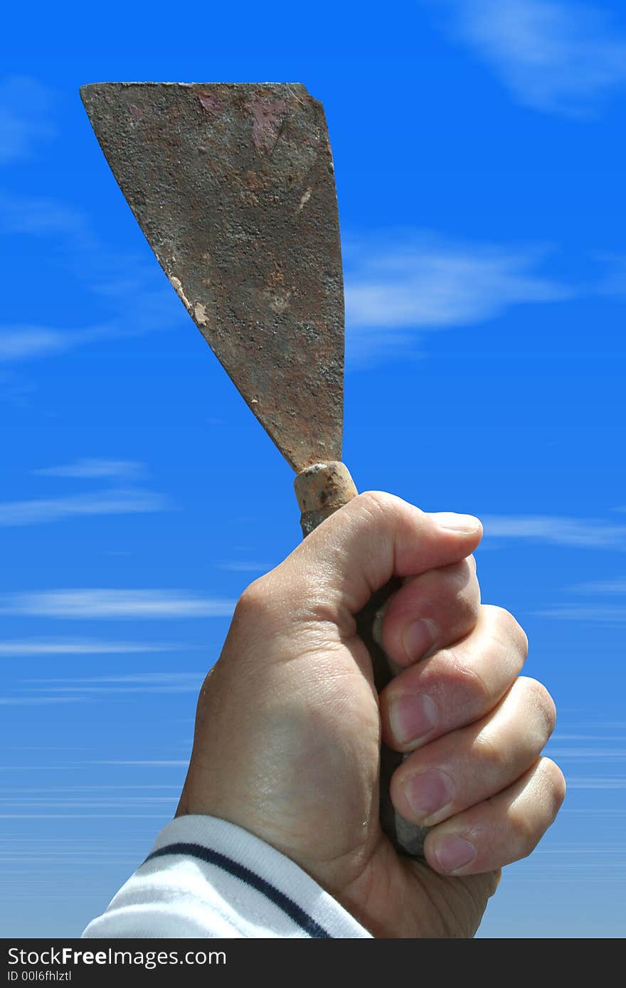 A spatula in hand with the sky of background