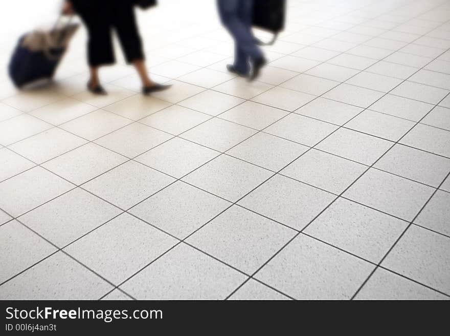 Passengers with luggage walking in an airport terminal. Passengers with luggage walking in an airport terminal