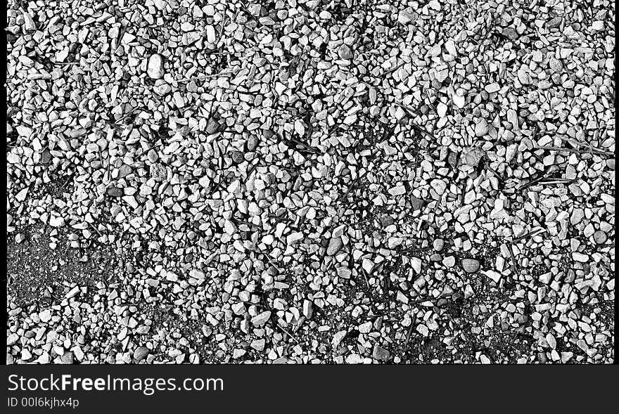 Black and white pebbles of different constiution on the road.  This is great for a background for anything colorful,
or a logo for it to show through. Black and white pebbles of different constiution on the road.  This is great for a background for anything colorful,
or a logo for it to show through.