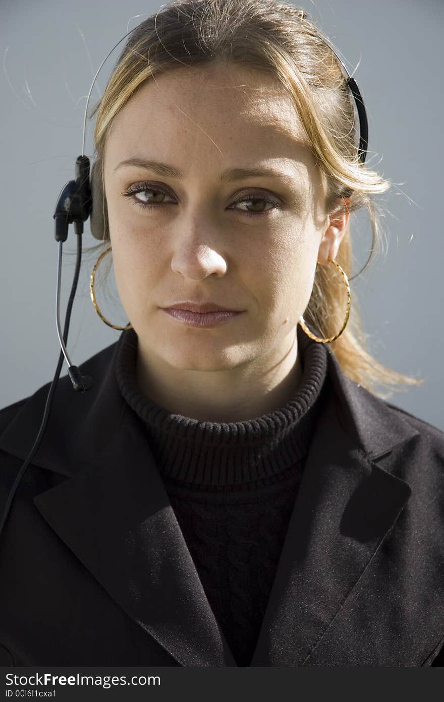 An isolated picture of a young female telemarketer / customer support officer, smiling as she works with a headset and microphone on her head. An isolated picture of a young female telemarketer / customer support officer, smiling as she works with a headset and microphone on her head.