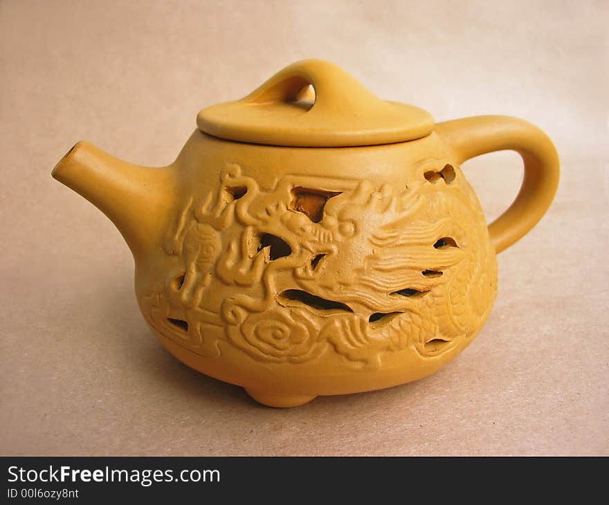 Teapot on brown paper background