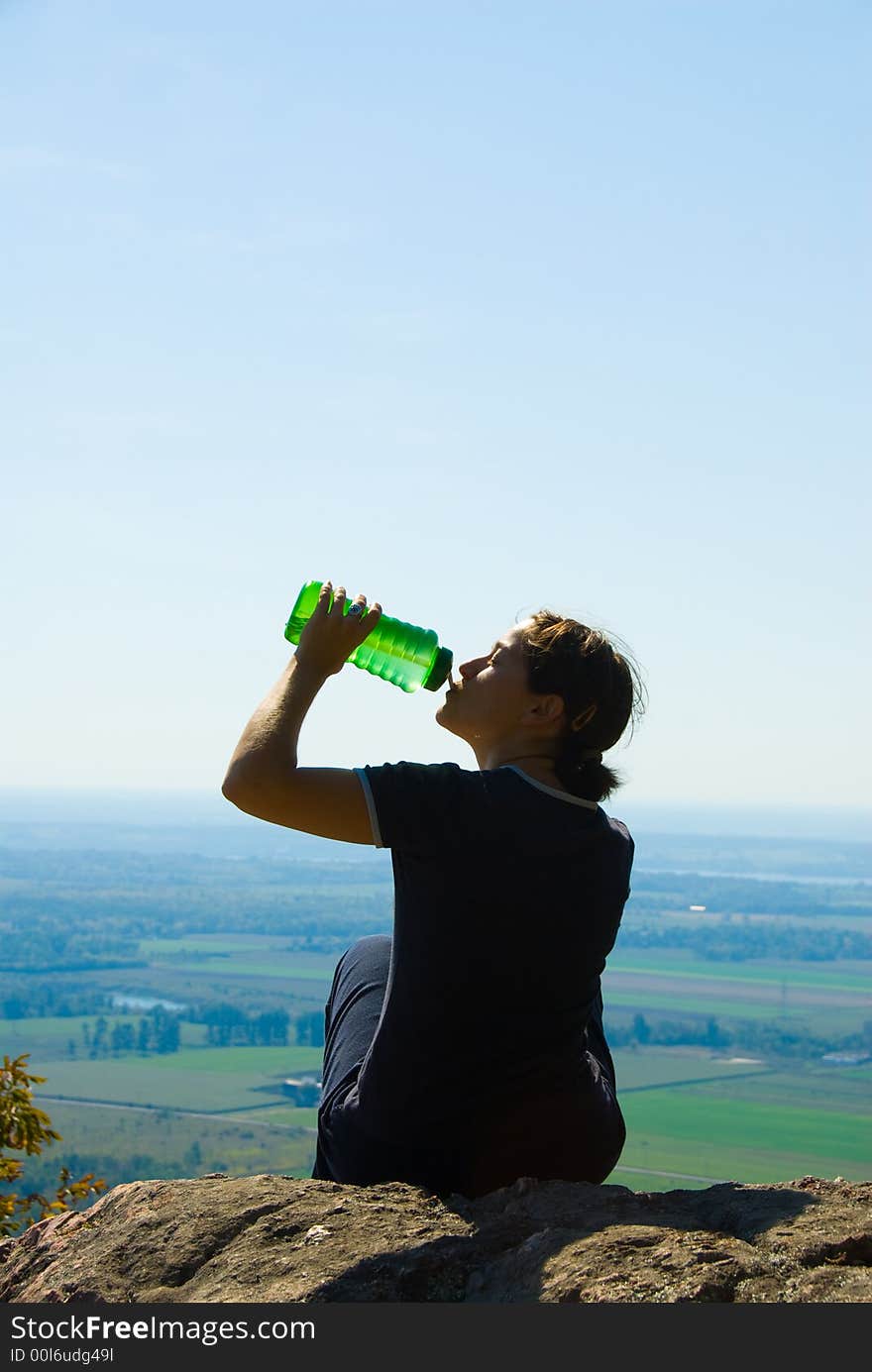 Drinking woman on top of a mountain. Drinking woman on top of a mountain