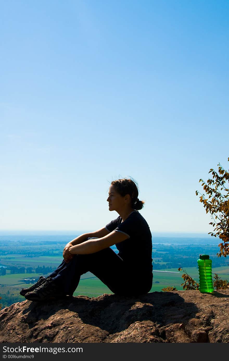 Sitting woman on top of a mountain. Sitting woman on top of a mountain