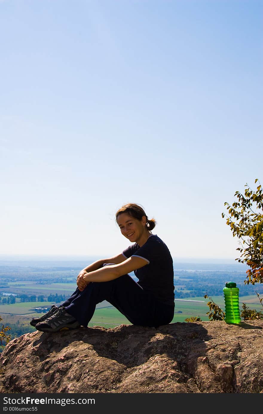 Sitting woman on top of a mountain. Sitting woman on top of a mountain