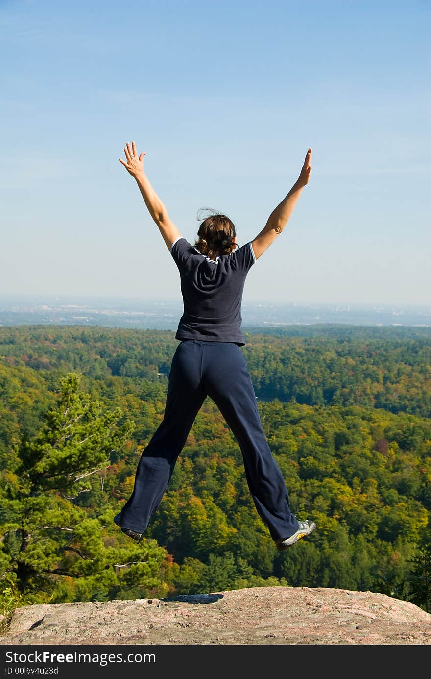 Woman on the top of a mountain happy jumping. Woman on the top of a mountain happy jumping