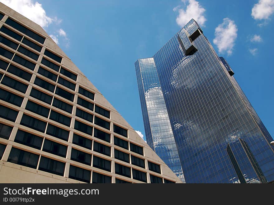 Office buildings with clouds reflecting off of their surface. Office buildings with clouds reflecting off of their surface.