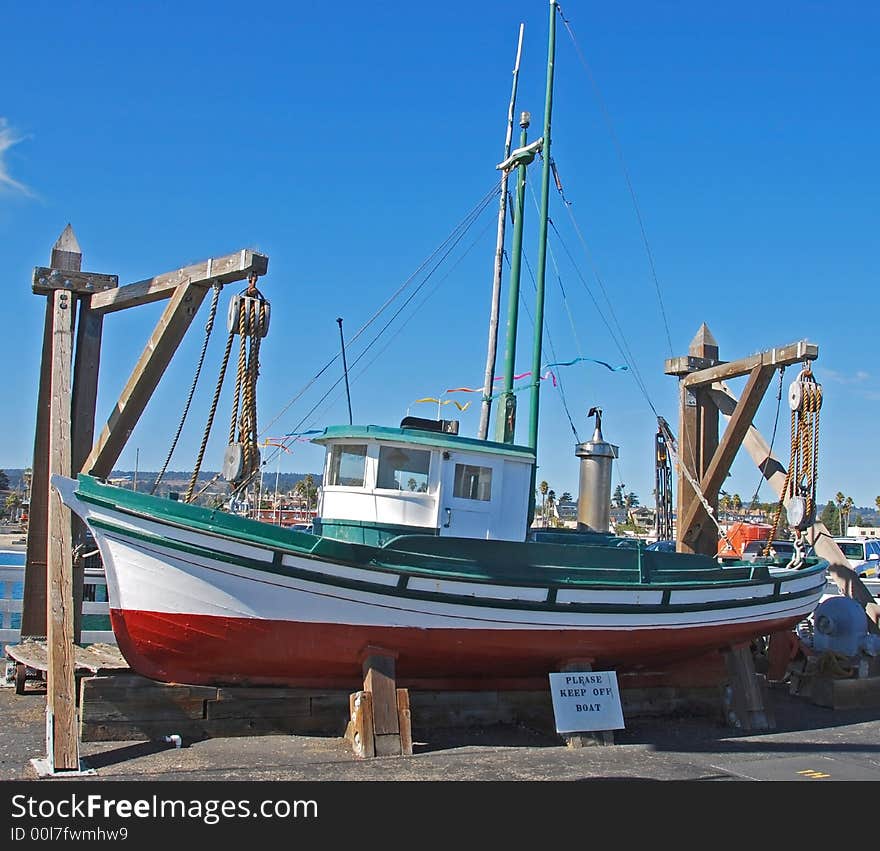 Colorful fishing boat in dry dock on a fishing pier. Colorful fishing boat in dry dock on a fishing pier