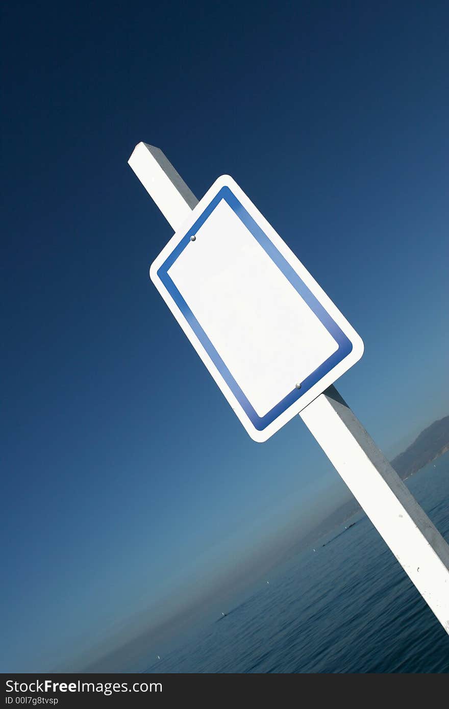 White sign in front of a nice background of blue sky and the ocean. White sign in front of a nice background of blue sky and the ocean