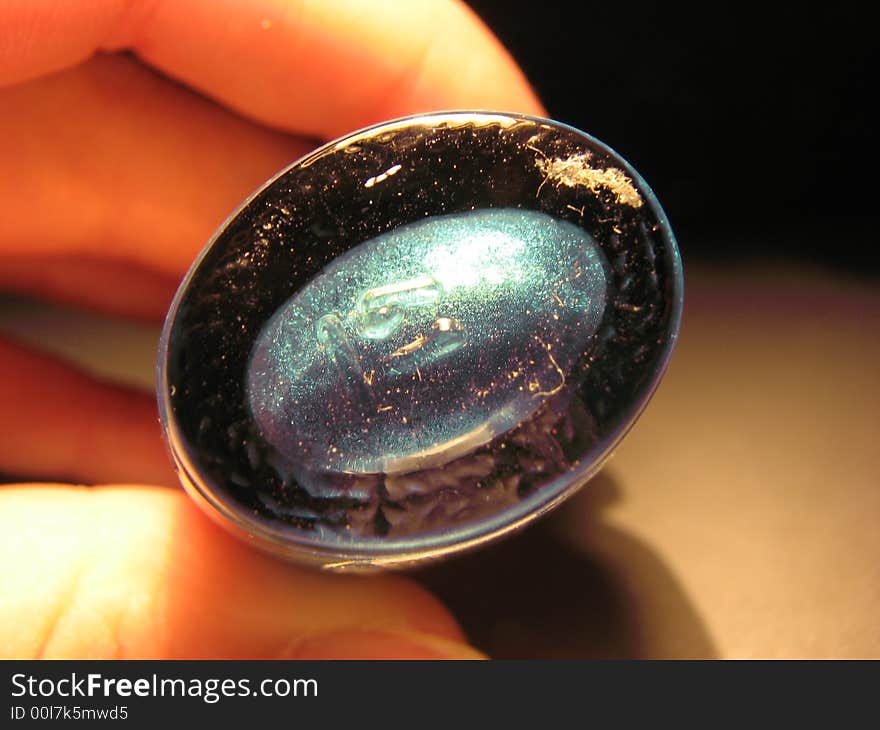 Round bottom of turquoise enamel in glass bottle.