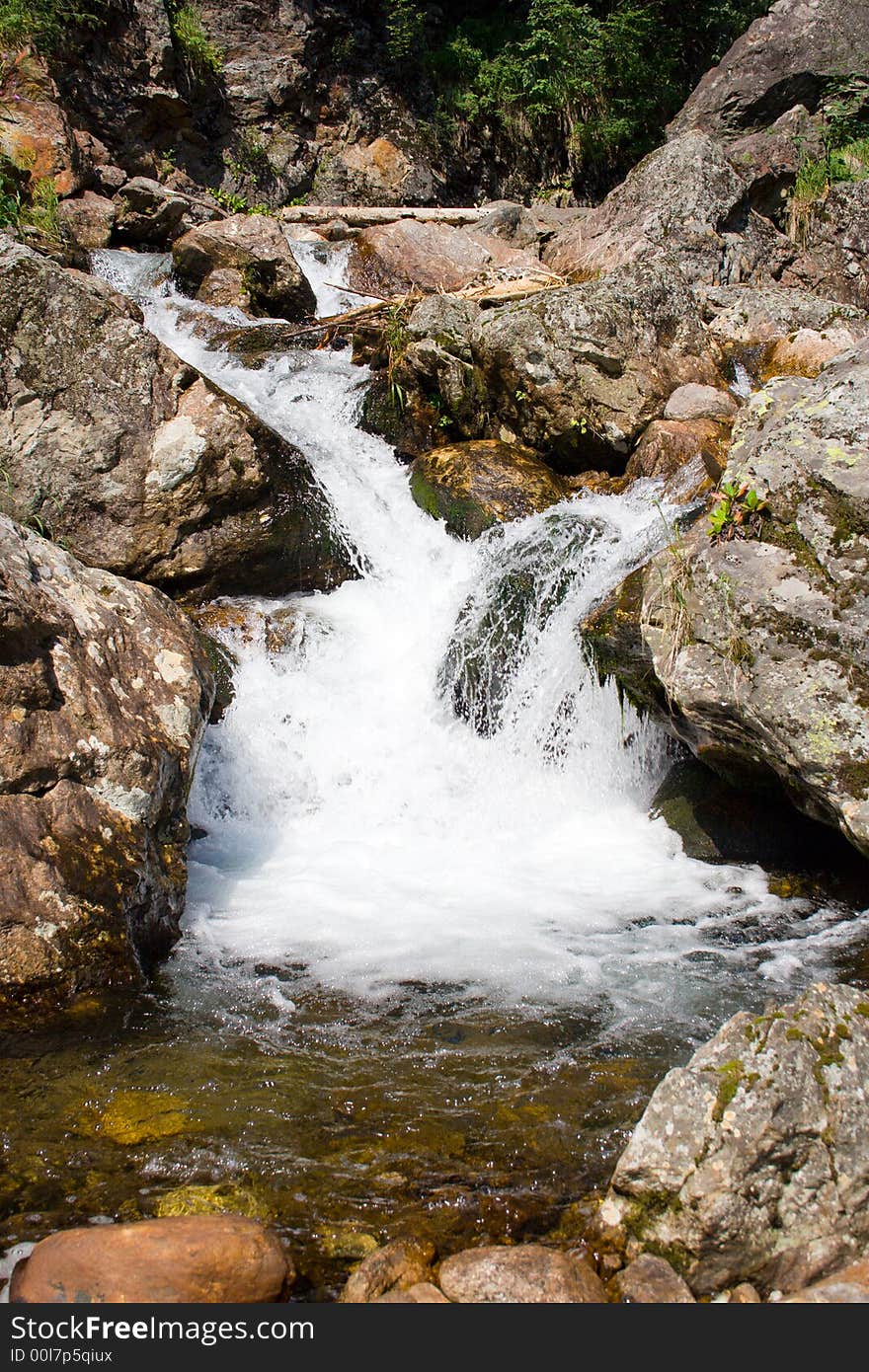 Mountain stream running over mossy rocks in siberia (foothills of Sayan's mountain range)