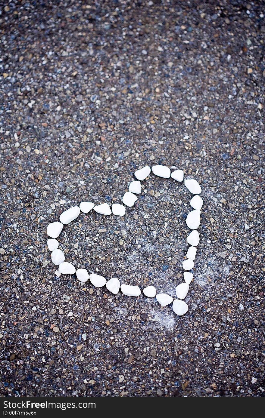 White stones on asphalt. Heartshaped. White stones on asphalt. Heartshaped.