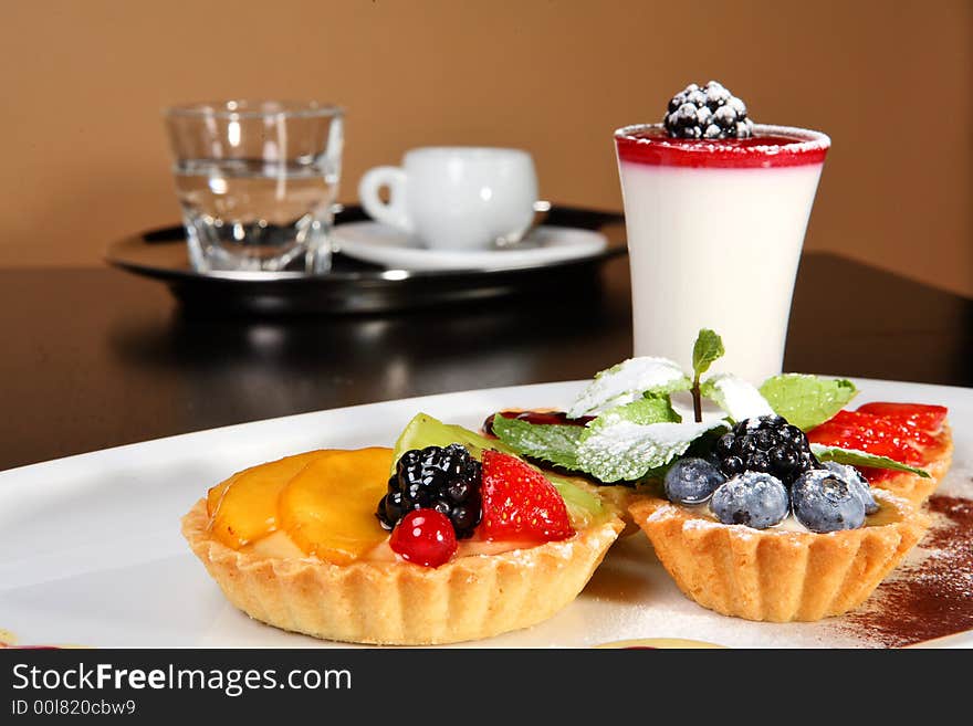 Mixed desert plate with panacotta and summer berries accompanied by coffee tray