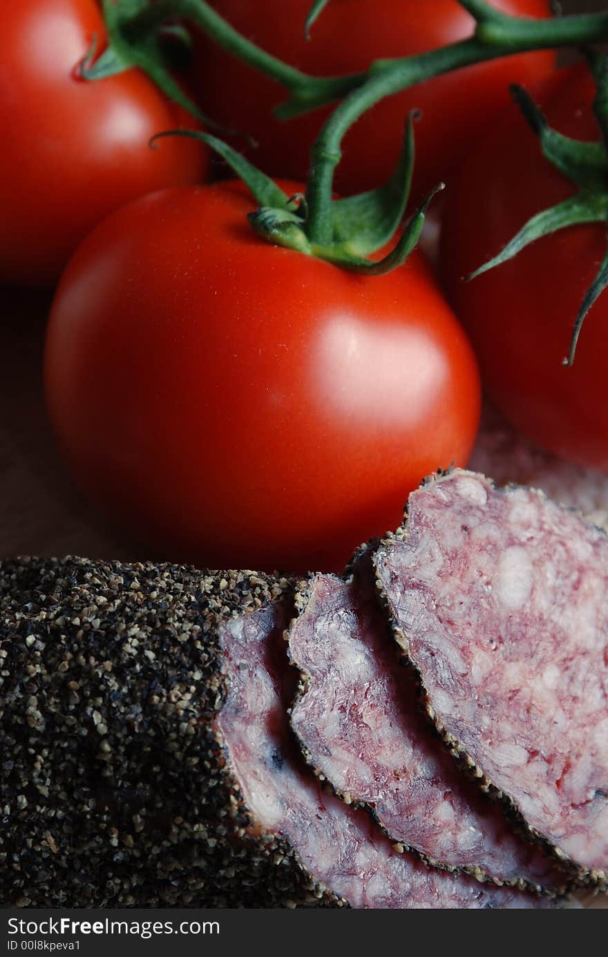 Piled up ingredients to make a risotto or paella, focus on sliced salami and vine tomatoes. Piled up ingredients to make a risotto or paella, focus on sliced salami and vine tomatoes