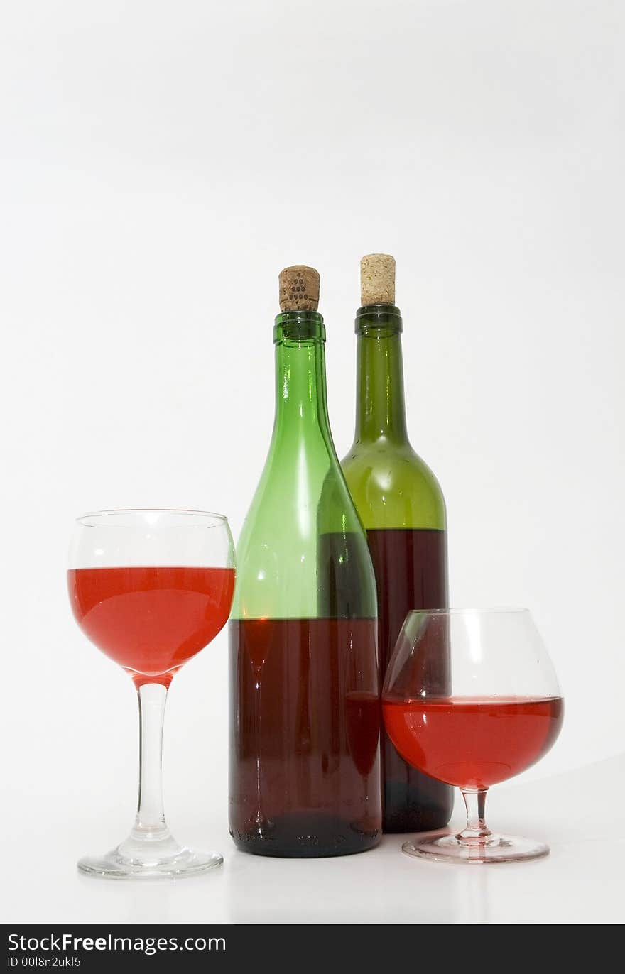 Red wine bottles and glasses isolated over white