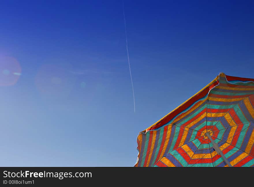 Colorful sunshade against a clear blue sky