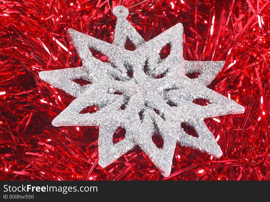 Silver glitter snowflake on red tinsel