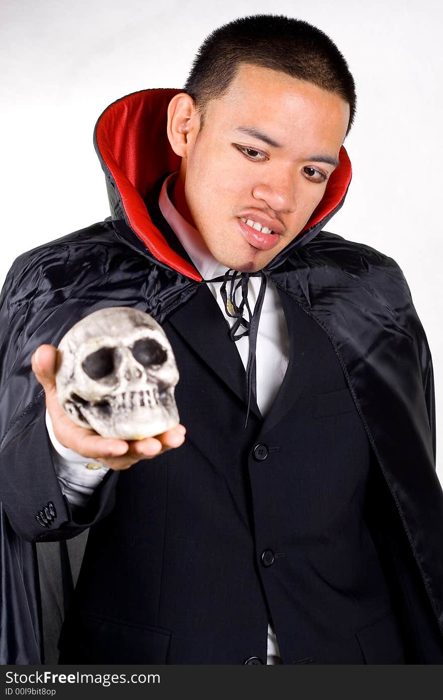 Scary dracula holding a skull. Scary dracula holding a skull