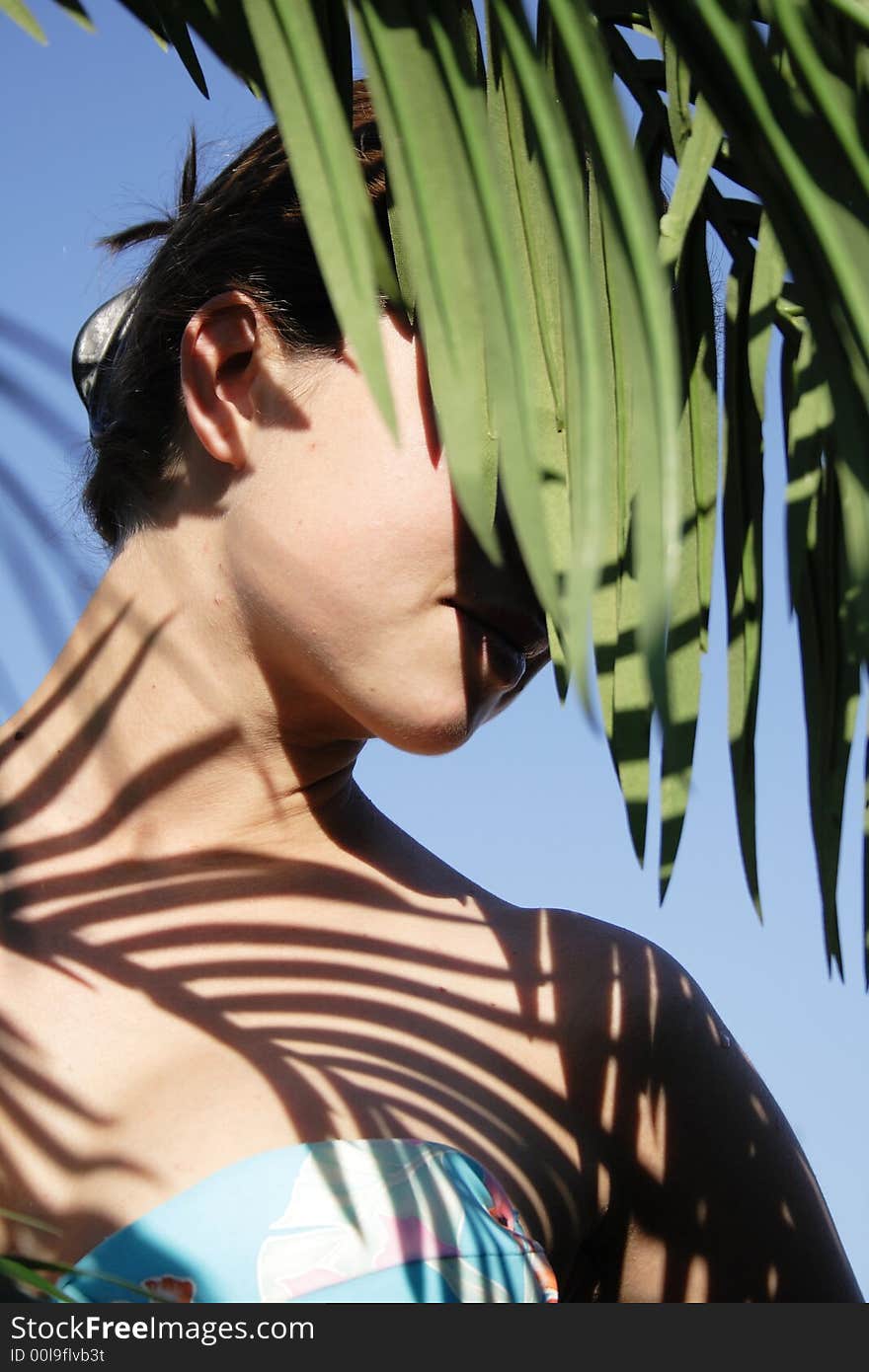 Beautiful woman in bikini with leafy shade