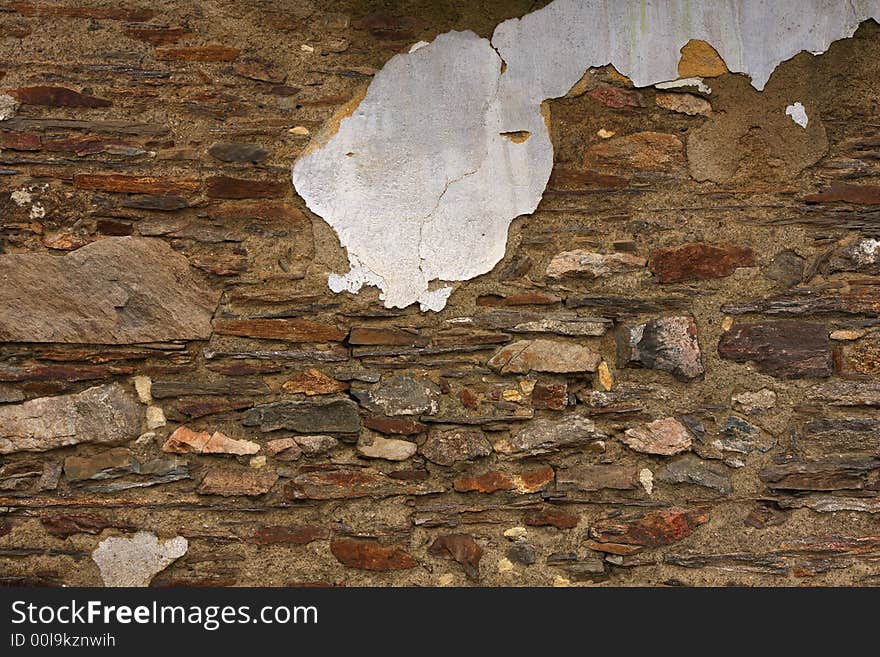 An old wall with chip of stucco. Stonework texture.