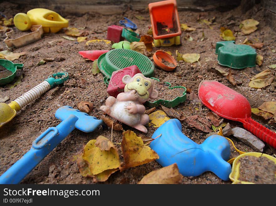 Forgotten toys in a dirty sandbox. Depressive mood. Forgotten toys in a dirty sandbox. Depressive mood.