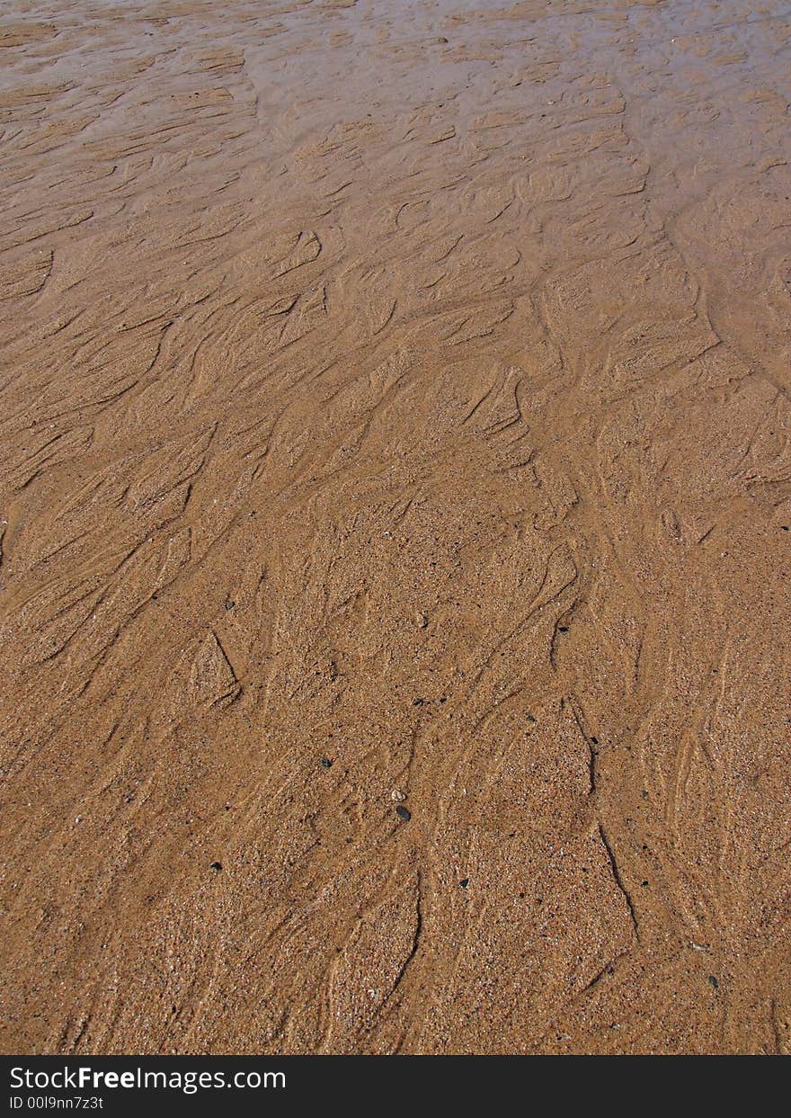 Wet sand on English beach, Cornwall, with small rivers running from the sea. Wet sand on English beach, Cornwall, with small rivers running from the sea