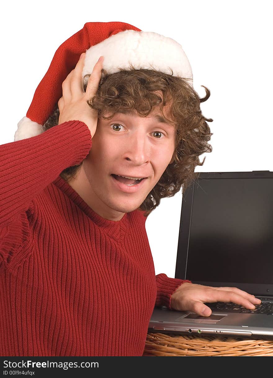 Young the man in cap Santa Claus with a computer on a white background. Young the man in cap Santa Claus with a computer on a white background