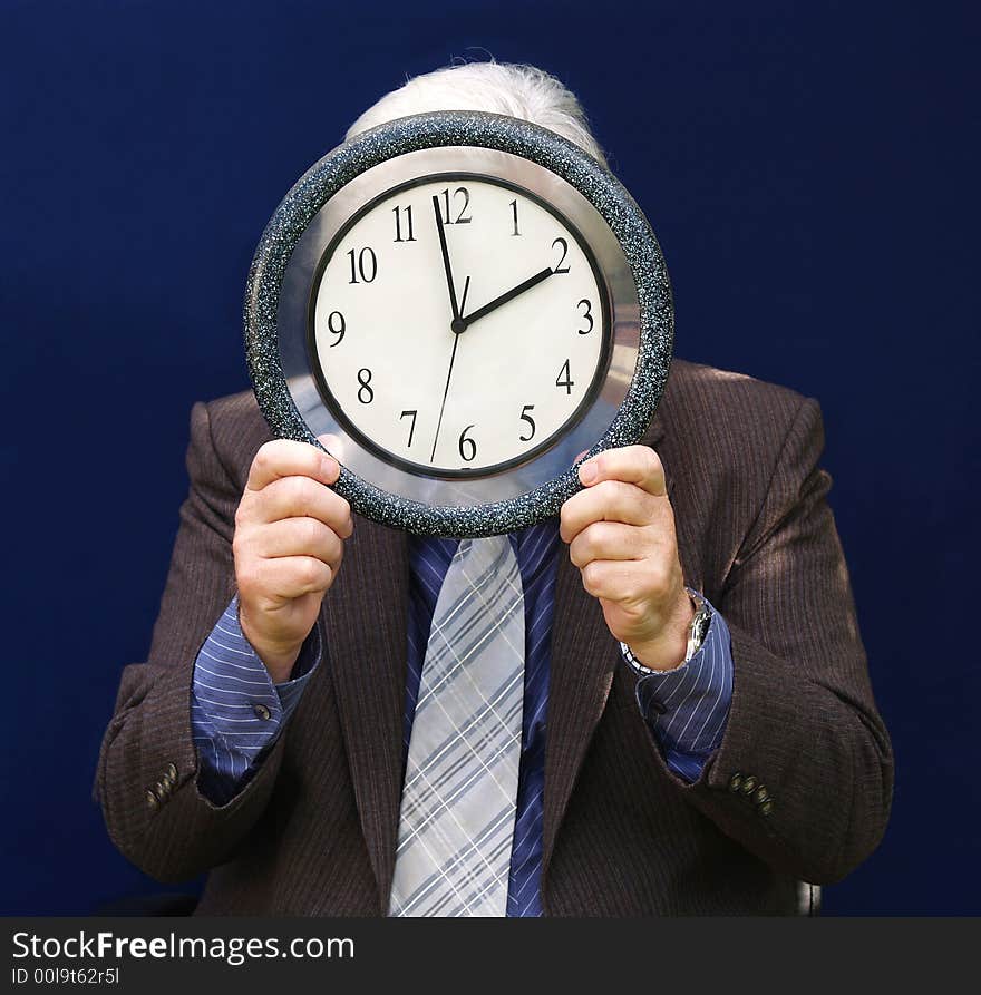 Senior executive holding a clock with end of Lunch Time