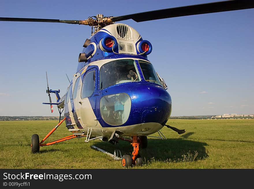 Blue helicopter on green grass