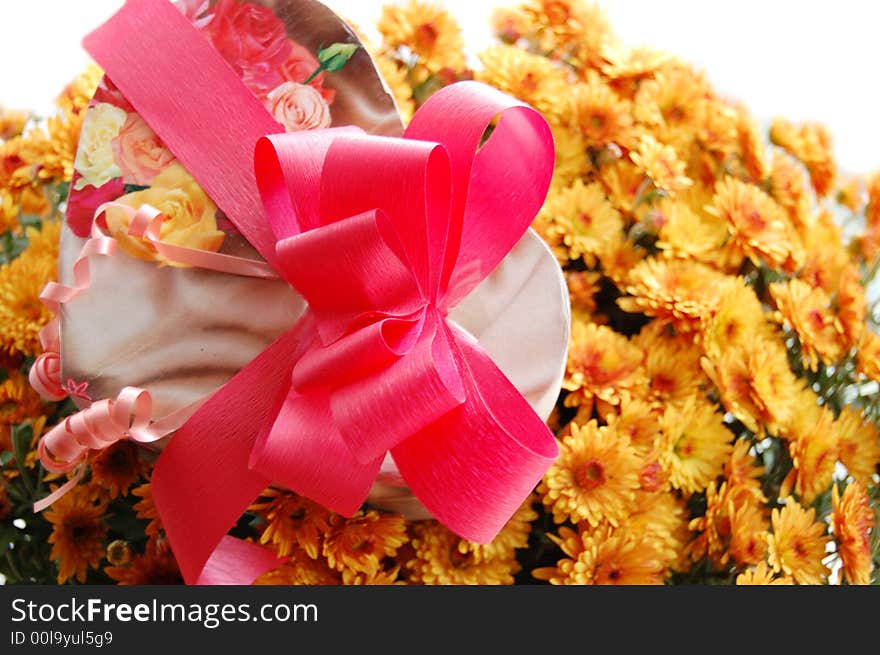 Present box with pink ribbon and bouquet of chrysanthemums. Present box with pink ribbon and bouquet of chrysanthemums