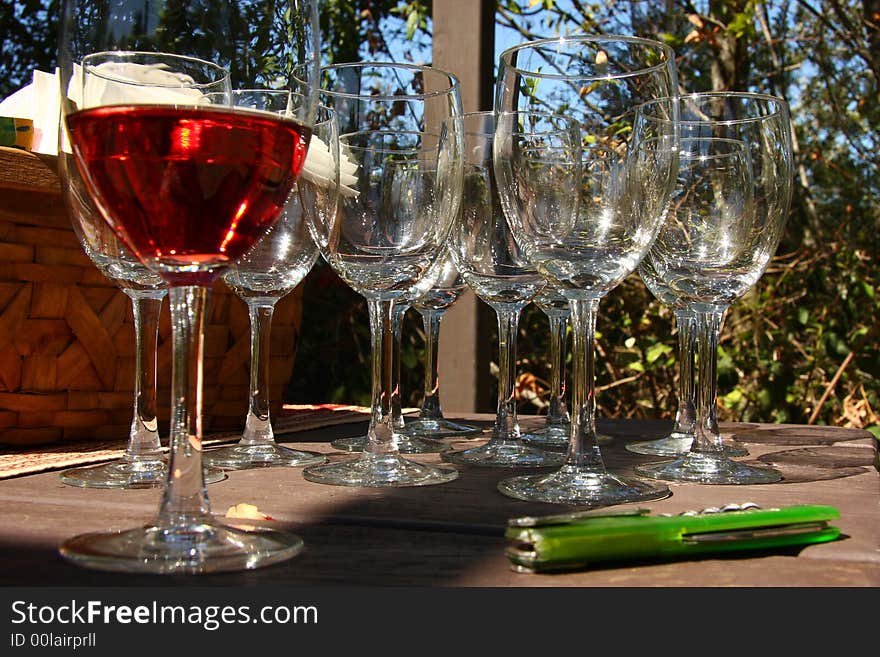 Glass of wine with empty glasses in background and bottle opener. Glass of wine with empty glasses in background and bottle opener