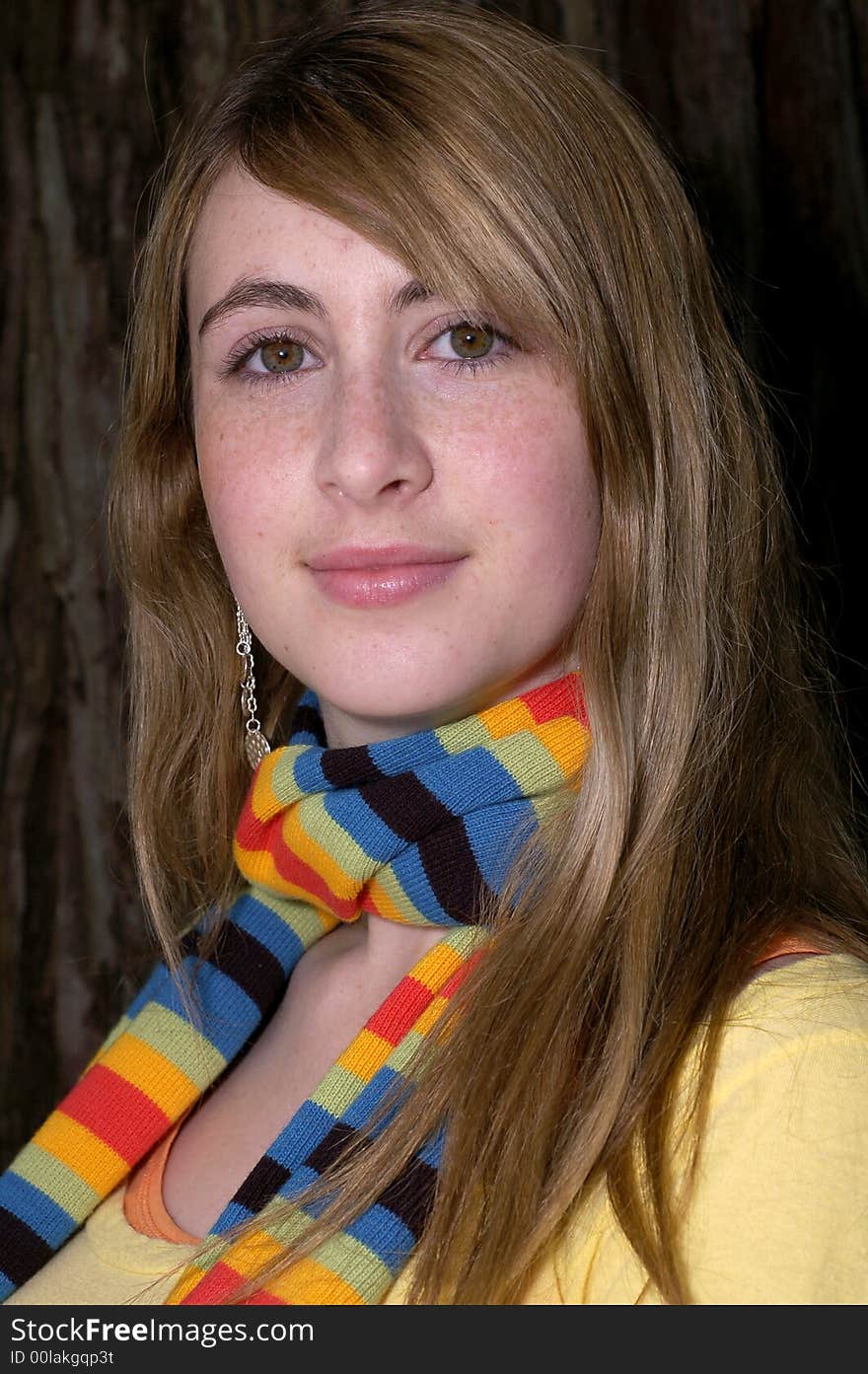 Young beautiful teen outdoors under a tree. Has a fall or winter season look.