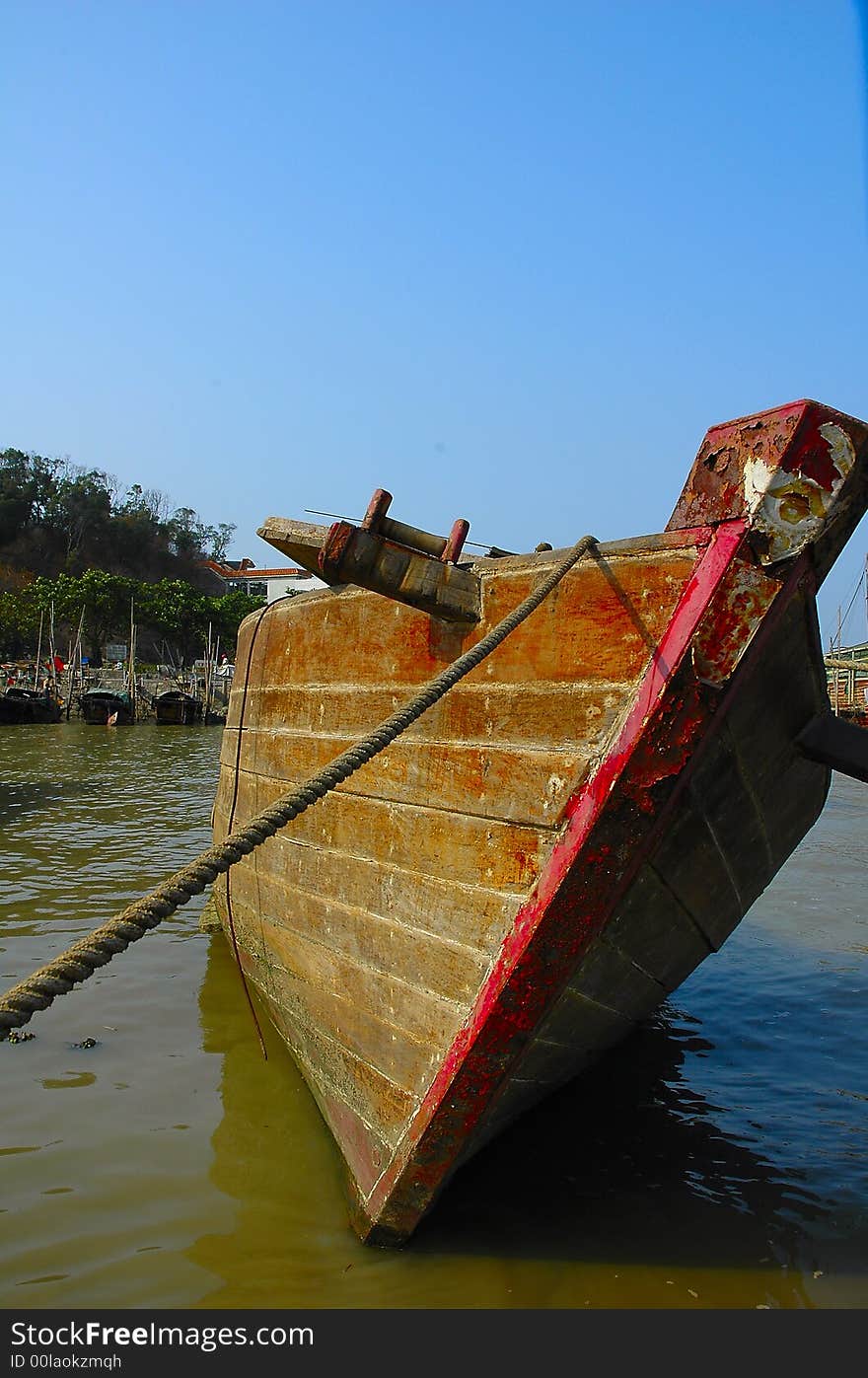 An old boat lies in the dirty water, what makes me think of its past