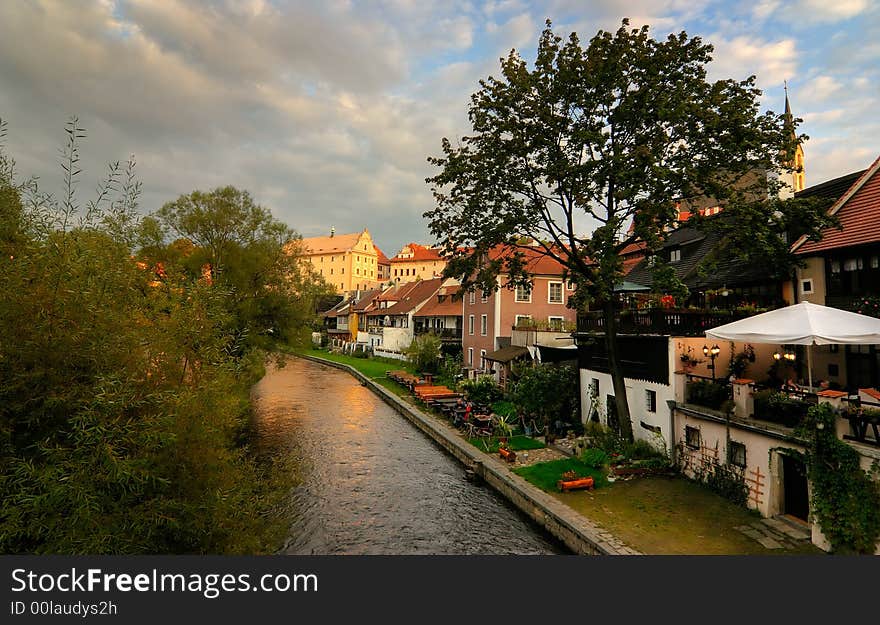 View of the Vltava River in the old city of Cesky Krumlov (Bohemia, Czech Republic), at sunset, with pubs and old houses. View of the Vltava River in the old city of Cesky Krumlov (Bohemia, Czech Republic), at sunset, with pubs and old houses.