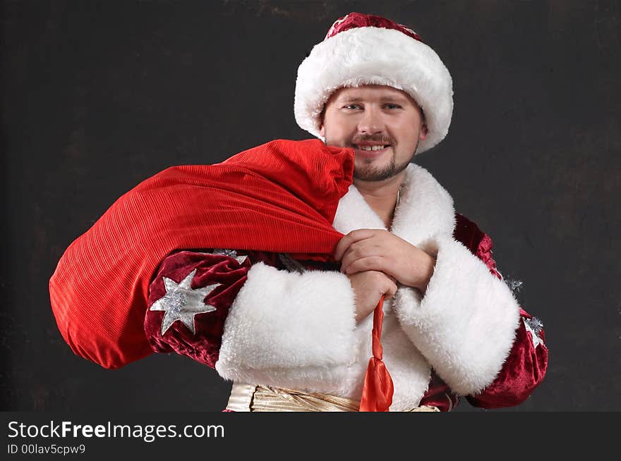 Santa Claus carrying a bag with gifts. Santa Claus carrying a bag with gifts