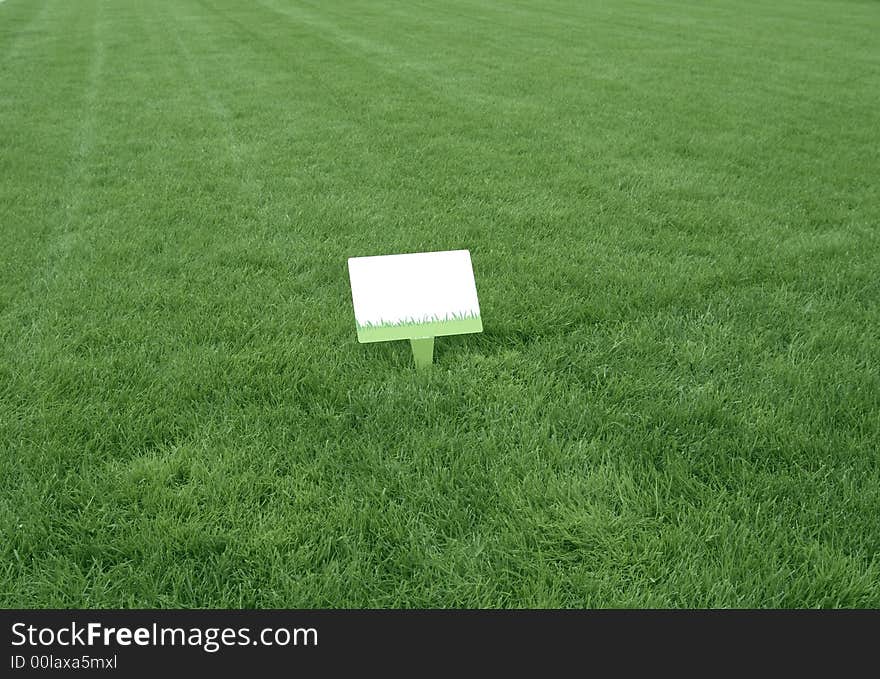 Fresh green grass background with a white sign ready to write