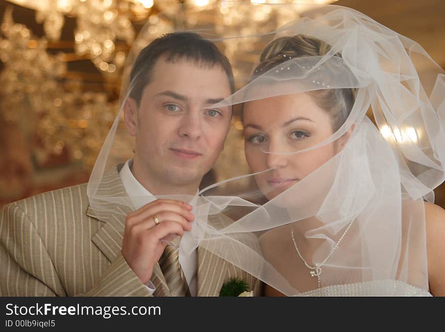 The groom and the bride in day of the wedding sit down in the machine decorated festively.