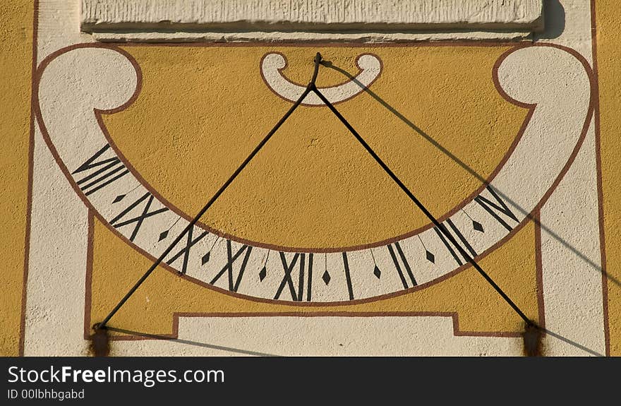 Old baroque sundial in  bright sunlight showing four o clock pm