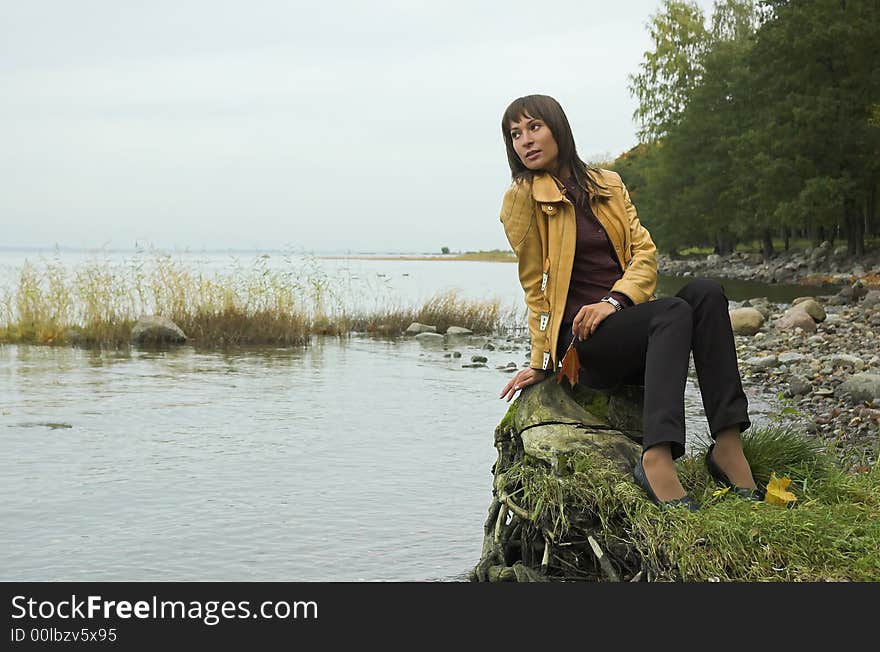 The beautiful girl on coast of a reservoir