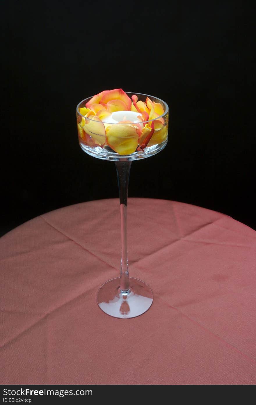 An image of a beautiful votive candle holder with rose petals. An image of a beautiful votive candle holder with rose petals