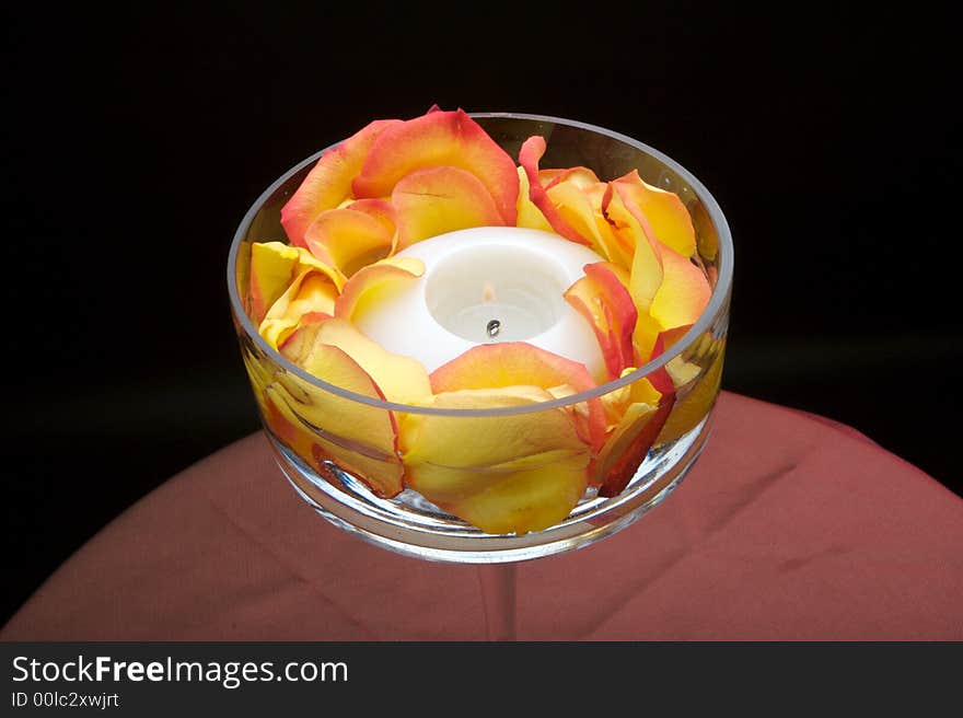 An image of a beautiful votive candle holder with rose petals. An image of a beautiful votive candle holder with rose petals