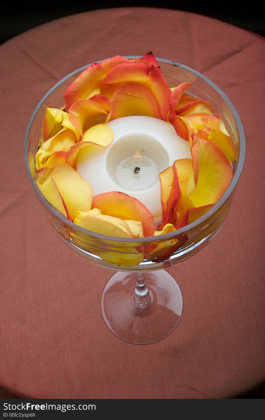 An image of a beautiful votive candle holder with rose petals. An image of a beautiful votive candle holder with rose petals