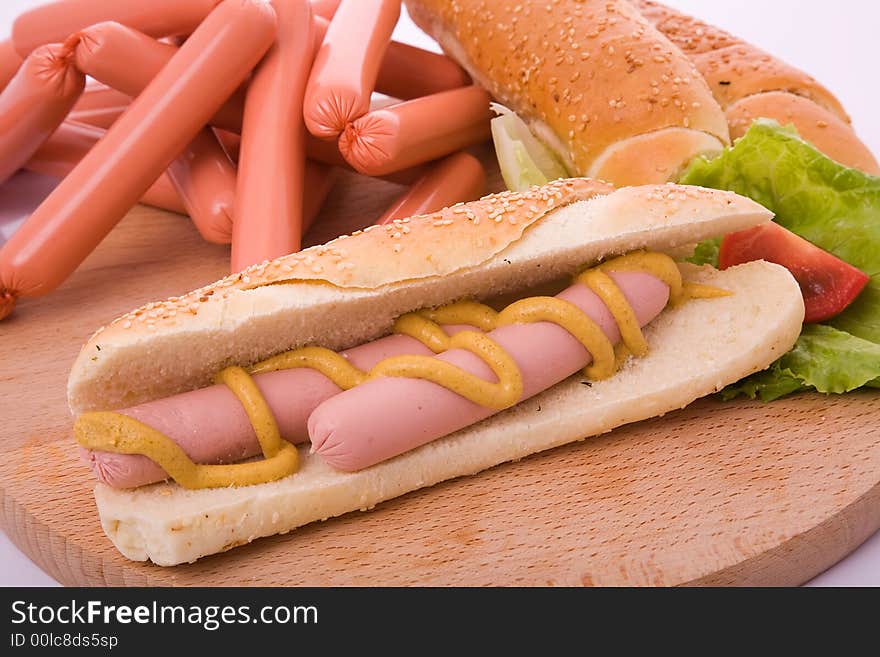 Hot dog on bun with yellow mustard