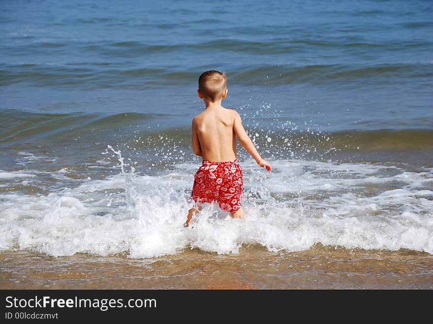 Boy splashing in the waves. Boy splashing in the waves