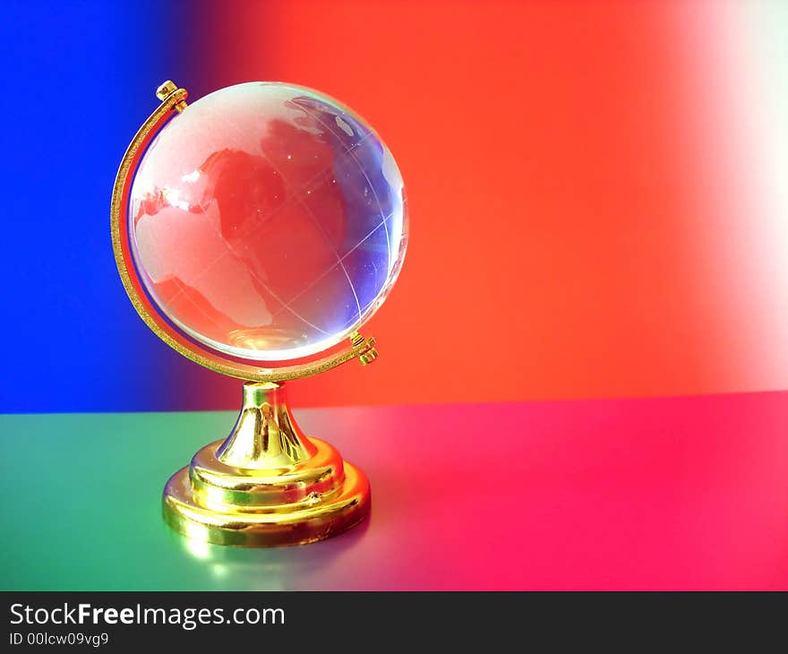 Glass globe of the world on colored background